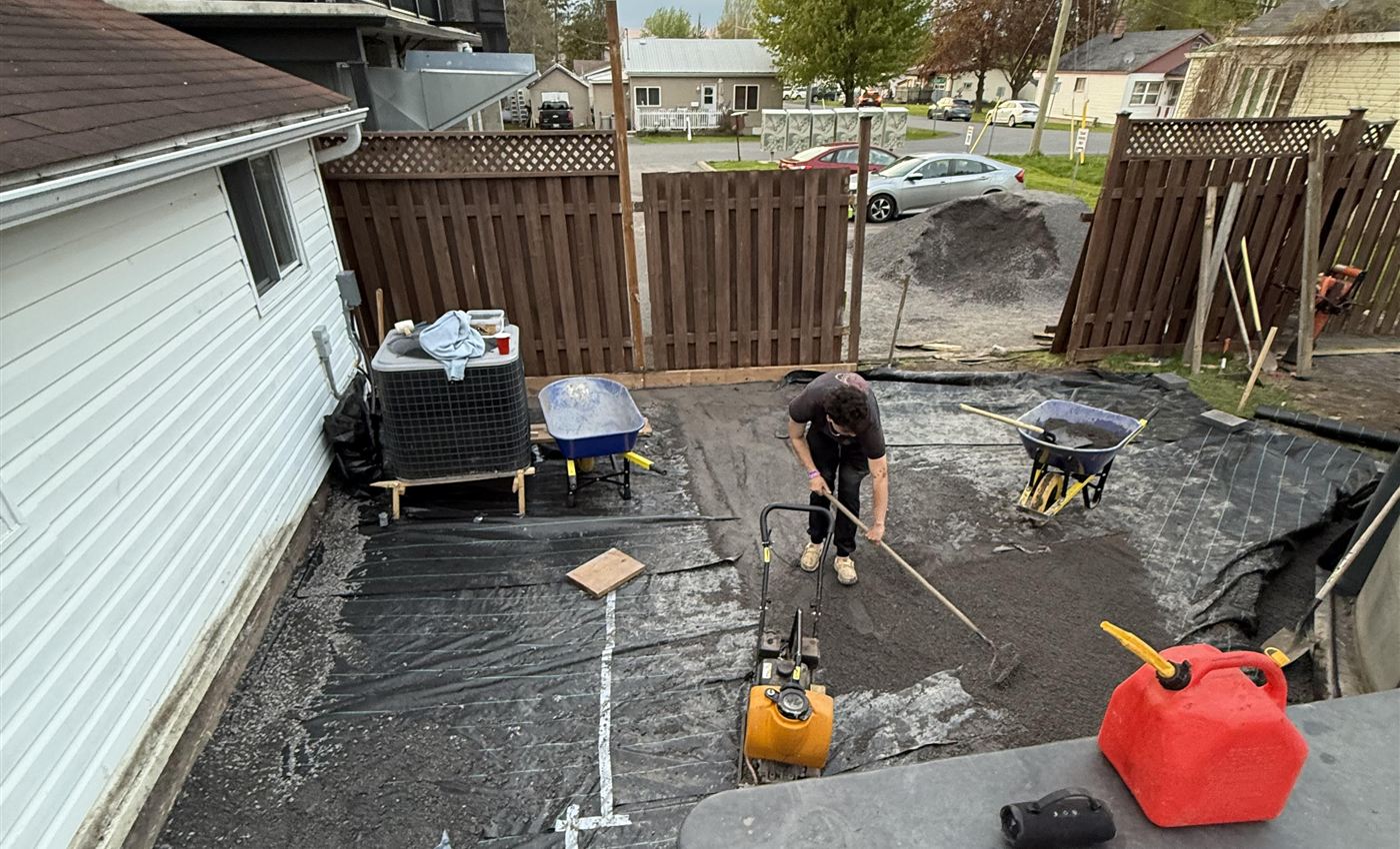 Lauzon crew compacting and grading the engineered base over geotextile before paving