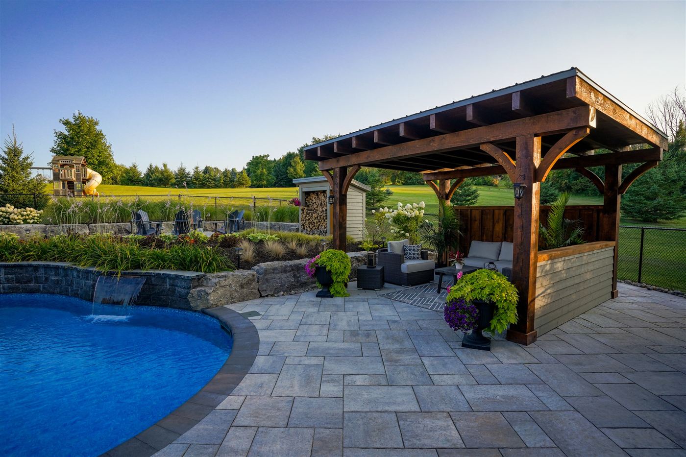 Interlock pool deck with a timber pavilion and water feature built by Lauzon Home Services